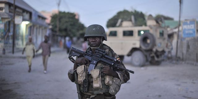 An AMISOM soldier monitors a street in Mogadishu. Gunmen killed two Somalis and wounded a Swedish woman in central Mogadishu on Wednesday when they opened fire on their car in the latest attack in the troubled city, police said.