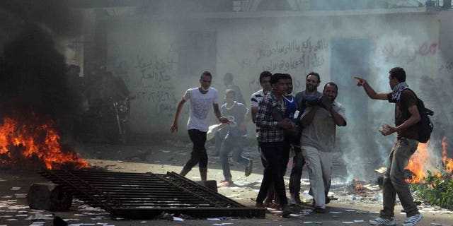 Egyptian Muslim Brotherhood supporters carry a wounded man in Cairo's Ramses square on August 16, 2013. EU foreign ministers Wednesday agreed to suspend the sale of security equipment and arms to Egypt, a statement said.