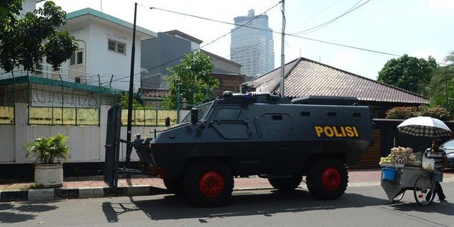 An Indonesian police armored vehicle (C) stands posted outside the Myanmar embassy compound (back L) in Jakarta before the arrival of anti-Myanmar demonstrators on May 3, 2013. Indonesian police have arrested four men suspected of involvement in a failed plot to bomb the Myanmar embassy in Jakarta, an official said Wednesday.