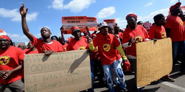 Workers on strike hold signs as they take part in a demonstration outside Ford's plant in Pretoria on August 20, 2013. South African 12-month consumer price inflation jumped to 6.3 percent in July from 5.5 percent in June due to higher fuel prices, official figures showed on Wednesday.