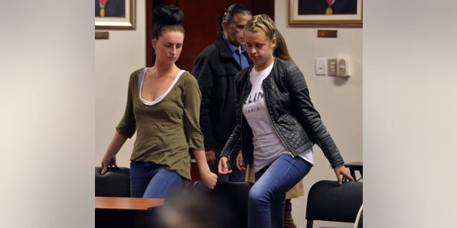 Irishwoman Michaella McCollum (L), 20, and Briton Melissa Reid, 19, are seen after a short recess at the Callao courtroom on August 21, 2013. A Peruvian judge has ordered that the two young women from Britain and Ireland be remanded in custody pending trial on drug trafficking charges.