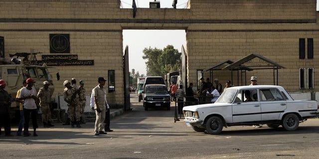 Egyptian security forces stand guard outside one of the gate of the Tora prison where former Egyptian president Hosni Mubarak is detained on August 21, 2013 in Cairo. Egyptians awaited Thursday the possible release of Mubarak after a court ordered he be freed pending his re-trial on charges of complicity in the deaths of protesters, and other crimes.