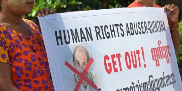 Ethnic Rakhine villagers hold a placard as they demonstrate during the visit of UN human rights envoy Tomas Ojea Quintana in Sittwe, Myanmar on August 12, 2013. Myanmar police on Thursday rejected allegations that a convoy carrying a UN rights envoy though a town wracked by religious unrest was attacked by a mob, blaming a "misunderstanding" for the incident.