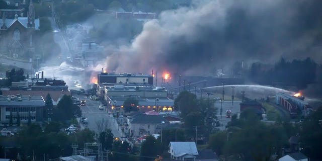 Firefighters douse blazes after a freight train loaded with oil derailed in Lac-Megantic in Canada's Quebec province on July 6, 2013. Canada's Senate called for a full safety review of pipelines, railroads and other means of transporting crude oil, in a report Thursday that also urges better responses to spills.