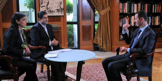 A handout picture from SANA on April 17, 2013 shows Syrian President Bashar al-Assad (R) during an interview in Damascus. Syrian President Bashar al-Assad appointed six new cabinet ministers on Thursday, the official SANA news agency reported, in a cabinet reshuffle targeting namely economic portfolios.