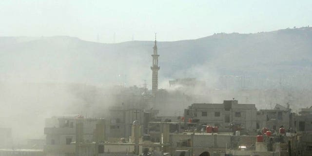 A handout image released by the Syrian opposition's Shaam News Network shows smoke above buildings following what Syrian rebels claim to be a toxic gas attack by pro-government forces in eastern Ghouta, on the outskirts of Damascus on August 21, 2013.