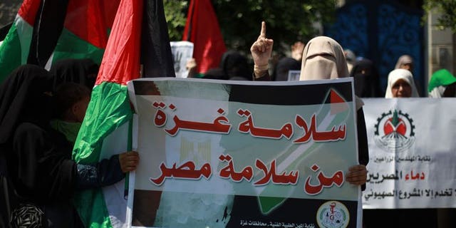 A female Palestinian protester carries a placard and gestures during a rally in support of ousted Egyptian president Mohamed Morsi, in Gaza City on August 19, 2013. Palestinian security services have arrested an Islamist sympathiser in the West Bank for selling perfume named in honour of Egypt's ousted president Mohamed Morsi, family members said on Thursday.