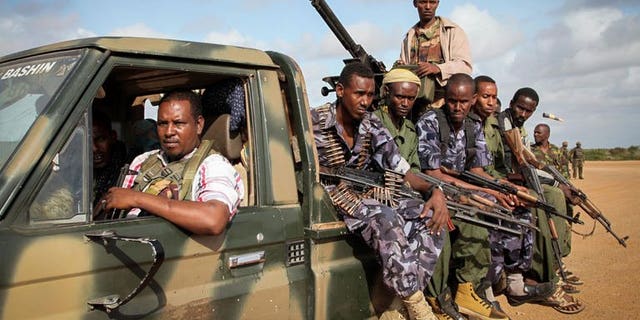 Fighters belonging to the pro-government Ras Kimboni Brigade ride on the back of a machine mounted truck at the Kismayo Airport in southern Somalia on August 22, 2013. African troops in Somalia said they thwarted an attack Thursday by Islamist Shebab fighters on their base in the southern port city of Kismayo.