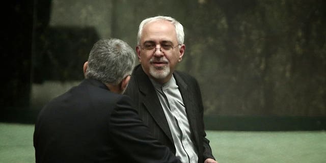 Mohammad Javad Zarif speaks with an MP in parliament in Tehran on August 15, 2013. The possession of a nuclear bomb would threaten Iran's security, the country's foreign minister, Mohammad Javad Zarif, said in comments reported on Friday.