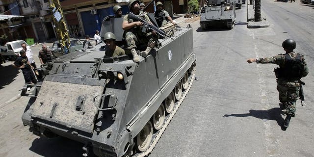 Lebanese army soldiers patrol Syria street in Tripoli's Sunni neighbourhood of Bab al-Tabbaneha on June 7, 2013. Two explosions went off within minutes of each other in the northern Lebanese city of Tripoli on Friday, an AFP photographer and the National News Agency reported.