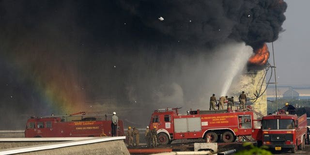 Indian firefighters battle to douse the flames of a burning fuel tank at the Indian Oil Corporation plant at Hajira near Surat, some 275 kms from Ahmedabad, on January 6, 2013. A massive fire broke out Friday at a petroleum refinery in southern India, killing four workers and leaving dozens injured, police said.
