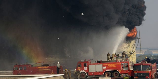 Indian firefighters battle to douse the flames of a burning fuel tank at the Indian Oil Corporation plant at Hajira near Surat, some 275 kms from Ahmedabad, on January 6, 2013. A massive fire broke out Friday at a petroleum refinery in southern India, killing four workers and leaving dozens injured, police said.
