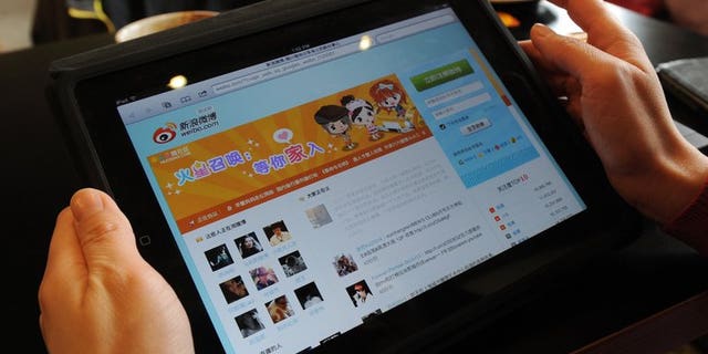 A woman views the Chinese social media website Weibo at a café in Beijing on April 2, 2012.