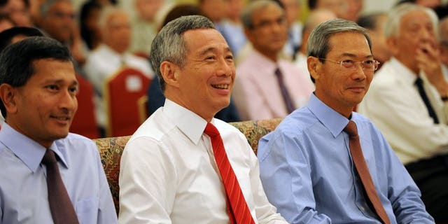 Singapore Prime Minister Lee Hsien Loong (centre) attends a book launch at the Istana Presidential Palace in Singapore on August 6, 2013. Singapore Prime Minister Lee Hsien Loong's efforts to connect with younger voters may finally pay off after a photo of him doing his first fist bump went viral on Facebook.