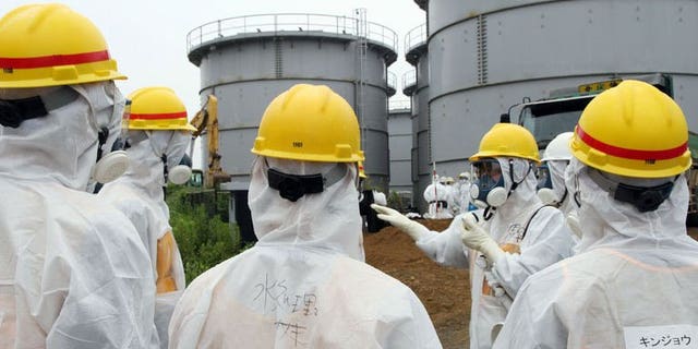 Japan's nuclear watchdog members, including Nuclear Regulation Authority members in radiation protection suits, inspect contaminated water tanks at the Tokyo Electric Power Co (TEPCO) Fukushima Dai-ichi nuclear power plant in the town of Okuma, Fukushima prefecture on August 23, 2013.