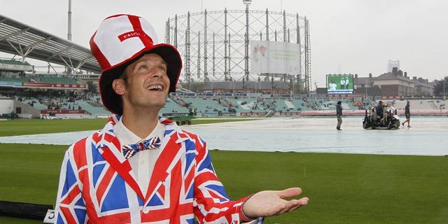 A spectator poses for a photograph after rain delays the start of the fourth day's play of the fifth Ashes cricket Test match between England and Australia at the Oval cricket ground in London on August 24, 2013.