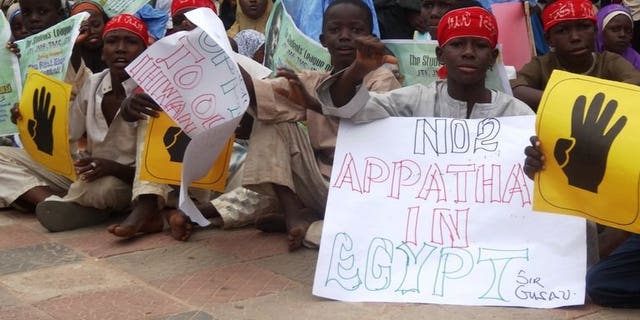 Young boys hold pro-Morsi placards during a protest on August 24, 2013 in Sheikh Ahmad Tijjani mosque, Kano, Nigeria. Thousands rallied peacefully in northern Nigeria to demand the return of Egypt's Islamist former president Mohamed Morsi, ousted by the military early last month.
