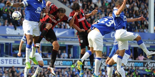 Everton's French defender Sylvain Distin (L) vies with West Bromwich Albion's Swedish defender Jonas Olsson (2nd L) during the English Premier League football match between Everton and West Bromwich Albion at Goodison Park in Liverpool on August 24, 2013. The game ended 0-0.