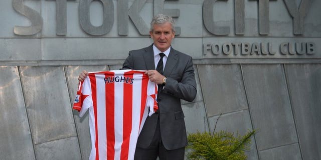Mark Hughes holds up a Stoke City football shirt at the Stoke City training ground in Stoke-on-Trent, on May 30, 2013. Stoke City stormed back from behind to beat Premier League new boys Crystal Palace 2-1 on Saturday and earn manager Hughes victory in his first home game.