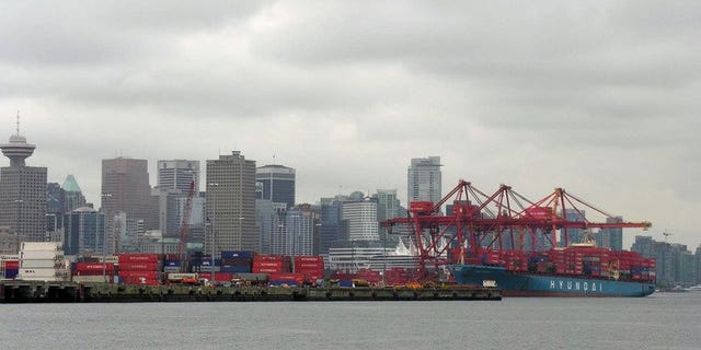 A container ship unloads in 2005 at the P&amp;amp;O Central Terminal in the Port of Vancouver. Canada's trade deficit doubled in July as imports increased and exports declined, the government statistical agency said Wednesday.