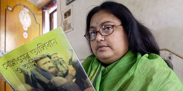 In this photograph taken on March 6, 2003, Indian author Sushmita Banerjee holds one of her Bengali language novels "Mollah Omar Taliban O Aami" (Mollah Omar, Taliban and Me) in Kolkata. Suspected Taliban militants have shot dead Banerjee in the eastern Afghan province of Paktika, police said.