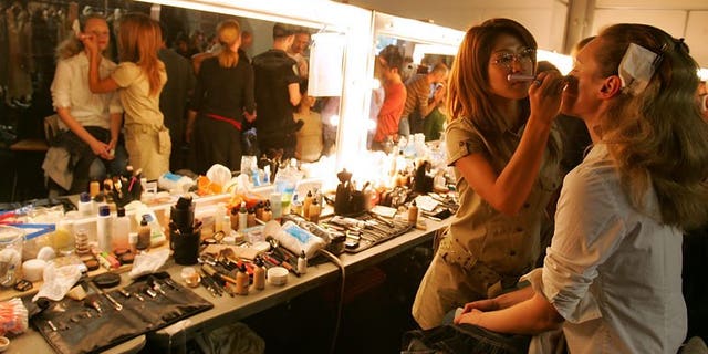 Models have final touches put to their hair and make-up in London, on September 19, 2005. Their skin is flawless, their make-up perfect and their hair sleek, but to teenage girls hoping to emulate fashion models, British Vogue has a message -- it's not real.