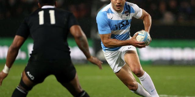 Juan Martin Hernandez of Argentina runs the ball back towards New Zealand's Julian Savea during their Rugby Championship match in Hamilton on September 7, 2013.