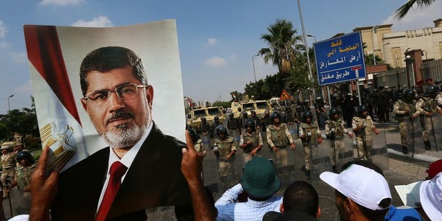 A supporter of ousted Egyptian president Mohamed Morsi holds a picture of the toppled leader in Cairo, on July 19, 2013. An Egyptian prosecutor has levelled new accusations against Mohamed Morsi, already facing trial on other charges, alleging the Islamist had insulted the country's judiciary when he was president, media reported.
