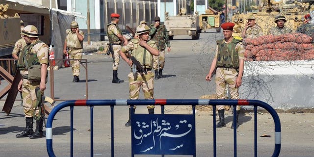 Egyptian soldiers stand guard in front of a prison in the Suez Canal city of Port Said on March 9, 2013. Egyptian military engineers have defused mortar rounds rigged to explode on a railroad linking the canal cities of Ismailiya and Suez, security officials said.