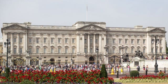 Tourists gather outside Buckingham Palace in central London on July 22, 2013. British police said they had arrested a man who scaled a fence to get into the palace, the official London residence of Queen Elizabeth II.