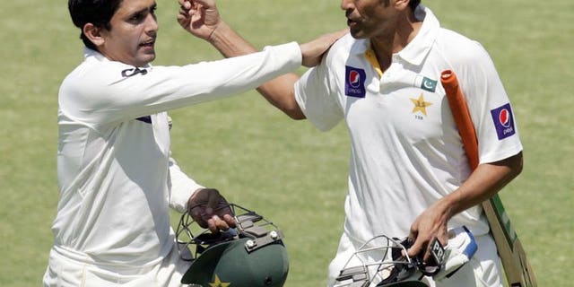 Pakistan batsman Younis Khan (right) is congratulated by Adnan Akmal (left) during the fourth day of the first cricket Test against Zimbabwe in Harare on September 6, 2013. Pakistan beat Zimbabwe by 221 runs on the fifth day.