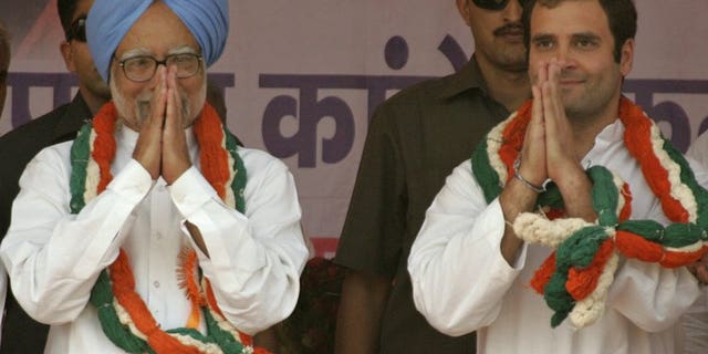 Indian Prime Minister Manmohan Singh (left) and Rahul Gandhi gesture to supporters during a rally in Banda, on April 30, 2011.