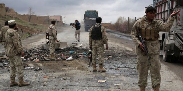 Afghanistan soldiers stand guard at the site of a roadside bomb blast in Saidabad district of Wardak province, on April 8, 2013. At least four Afghan intelligence agents were killed and dozens of civilians were wounded when a group of Taliban militants attacked an intelligence bureau in central Afghanistan.