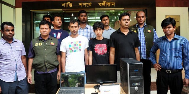 Bangladeshi police officials pose with three bloggers (C) during a press conference in Dhaka on April 2, 2013. Four Bangladeshi bloggers are facing up to seven years in jail after they were charged in court Sunday with defaming Islam and the Prophet Mohammed, a prosecutor told AFP.