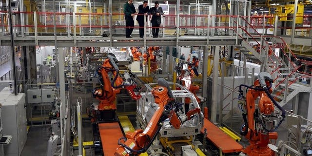 Prime Minister David Cameron (C) visits the Jaguar Land Rover (JLR) plant in Solihull on December 7, 2012. Indian-owned luxury carmaker Jaguar Land Rover says it will create 1,700 jobs at the British plant in a ??1.5-billion ($2.4-billion, 1.8-billion-euro) investment.