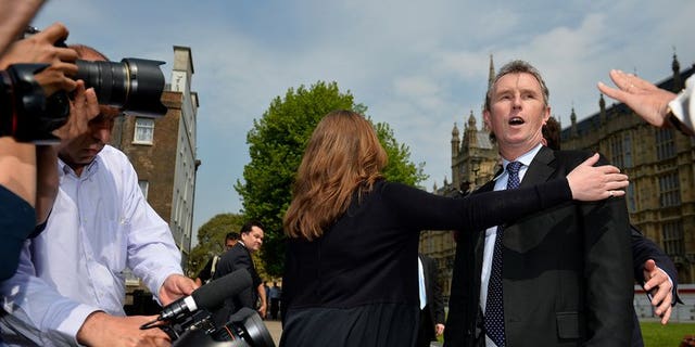 Journalists question deputy speaker Nigel Evans (R) outside London's Houses of Parliament, on May 7, 2013. Evans has been re-arrested on suspicion of indecent assault and sexually touching two further alleged victims, police said.