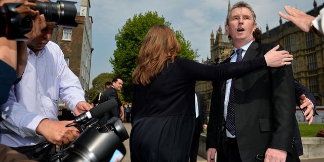 Journalists question deputy speaker Nigel Evans (R) outside London's Houses of Parliament, on May 7, 2013. Evans has been re-arrested on suspicion of indecent assault and sexually touching two further alleged victims, police said.