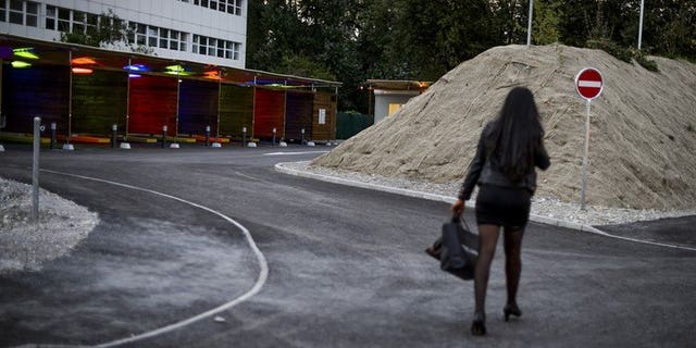 A prostitute walks past so-called "sex boxes" at the opening day of Switzerland's first sex drive-in on August 26, 2013 in Zurich. The Swiss parliament voted Tuesday to raise the legal prostitution age from 16 to 18, tightening the country's liberal sex-trade laws to bring them in line with European standards.