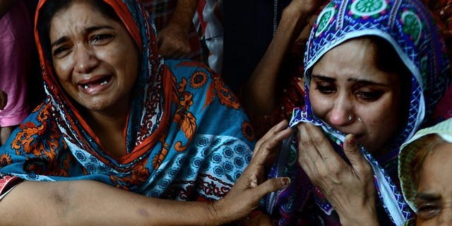 Pakistani women mourn the death of a relative who was killed after drinking toxic liquor in Karachi, on August 11, 2013. Toxic liquor has killed at least 12 people in central Pakistan, according to police and health officials.