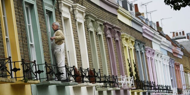 A decorator paints a window frame on a house in Camden in London, on November 3, 2008. The United Nations' special rapporteur on housing called for Britain to scrap its so-called "bedroom tax" because of its "shocking" impact on the poor and vulnerable, sparking an angry response from the government.