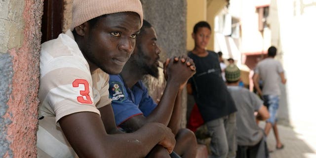 Senegalese immigrants sit in front of a building in Rabat on August 23, 2013. Morocco announced a new immigration policy, pledging to review cases according to specific criteria, following sharp criticism over its treatment of sub-Saharan migrants.