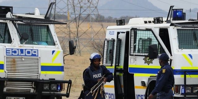 South African police carry weapons taken from stricking miners in Marikana on September 15, 2012. Hundreds of demonstrators marched on South African government buildings to protest at a lack of state funding for survivors of shootings at the Marikana mine, where 44 people died.