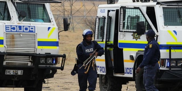 South African police carry weapons taken from stricking miners in Marikana on September 15, 2012. Hundreds of demonstrators marched on South African government buildings to protest at a lack of state funding for survivors of shootings at the Marikana mine, where 44 people died.