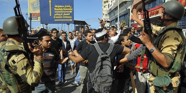 Egyptian soldiers patrol as supporters of the Muslim Brotherhood and Egypt's ousted president Mohamed Morsi clash with opposition demonstrators in Alexandria on September 6, 2013. Interim president Adly Mansour on Thursday extended by two months Egypt's state of emergency in force since mid-August, his spokesman said.