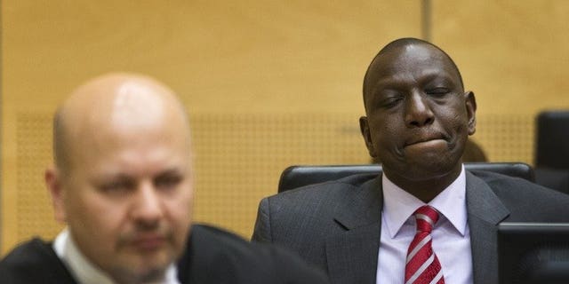 Kenya's Deputy President William Ruto (right) reacts as he sits in the courtroom before their trial at the International Criminal Court (ICC) in The Hague on September 10, 2013. Kenyatta has been "distressed" by the start of an international trial of his deputy for crimes against humanity,