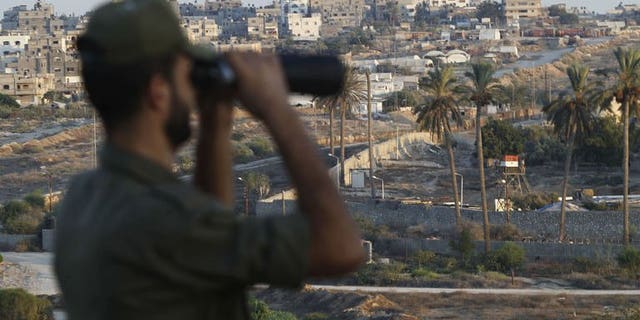 A Palestinian Hamas security guard looks through a pair of binoculars while on duty at the border between Egypt and Gaza Strip, in Rafah town southern Gaza Strip, on September 11, 2013.