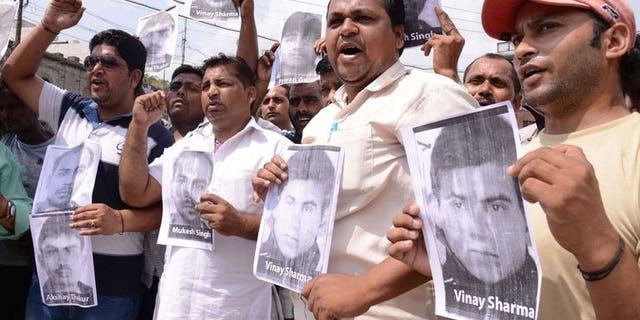 Indian activists of the Bhartiya Janta Party Scheduled Caste Morcha, shout slogans as they hold posters of four accused in a gang rape case of a student in New Delhi during a demonstration in Amritsar on September 11, 2013.