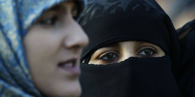 Veiled Muslim women stand at Marble Arch in London during a protest against French headscarf bans on January 17, 2004. One of Britain's biggest colleges on Friday dropped a ban on Muslim face veils after thousands of people signed a petition against the rule.