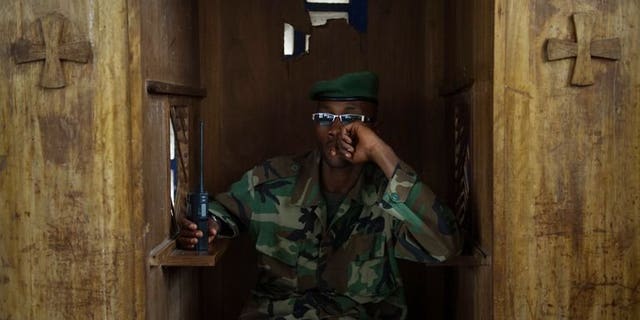 An M23 soldier sits in a confession booth in a church during a session to teach the rebel movement's values in Rumangabo in the east of the Democratic Republic of Congo, on July 20, 2013. Mediators in peace talks between Democratic Republic of Congo's government and M23 rebels admitted Friday the sides were yet to negotiate face-to-face, but insisted that progress was still being made.
