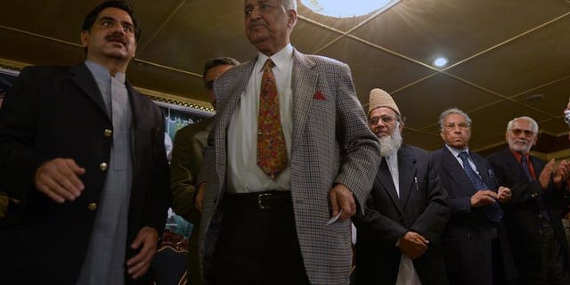 Former Pakistani nuclear scientist and chairman of Tehreek-e-Tahafuz Pakistan party, Abdul Qadeer Khan (2L), stands to give a speech during a public meeting in Islamabad on February 26, 2013.